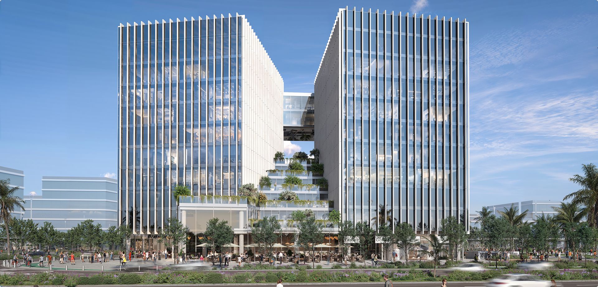 בניין משרדים מודרני מזכוכית עם סנפירים לבנים אנכיים, צמחייה על הגג וגשר אווירי במרכזו.