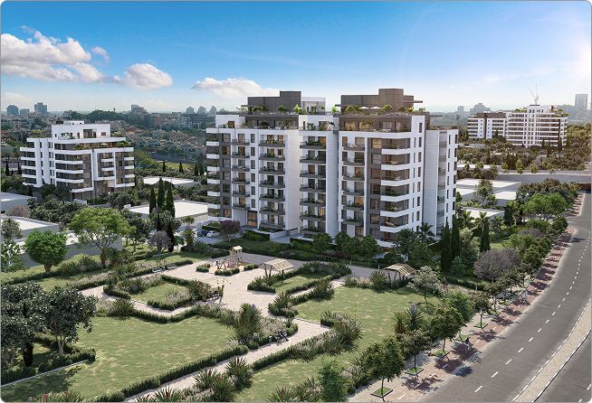 בנייני דירות מודרניים ולבנים עם מרפסות, המוקפים בגנים ירוקים ועצים, תחת שמיים כחולים.